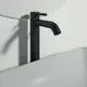 Schwarze Armatur von Ideal Standard mit Auslauf und Verlängerungssockel, montiert an einer hellen Wand. Die Armatur hat eine klare, minimalistische Form.